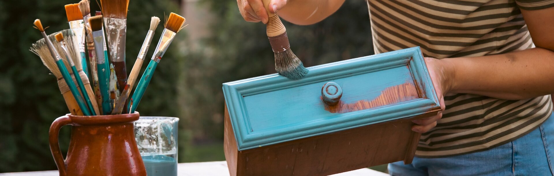 2493430637 | Mid woman painting furniture outdoors at home, relocation and diy concept.